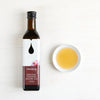 Kullanruskeaa Clearspringin paahdettua luomuseesamiöljyä kulhossa pullon vieressä puupöydällä