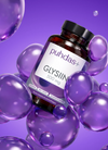 Puhdas+ Glysiini -pullo kelluu suurten kiiltävien violettien kuplien keskellä violetilla taustalla